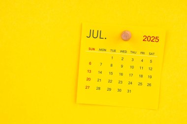 Sarı arkaplanda raptiyesi olan Temmuz 2025 takvim sayfası.