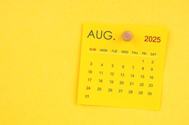 Sarı arkaplanda raptiyesi olan Ağustos 2025 takvim sayfası.