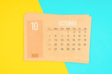 Sarı ve mavi arka planda 2025 Ekim ayı için kahverengi takvim kartı.