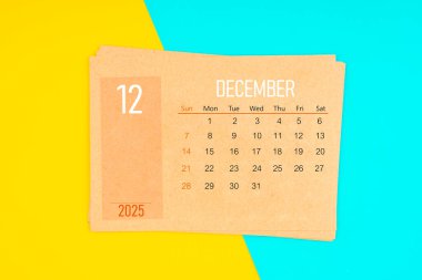 Sarı ve mavi arka planda Aralık 2025 için kahverengi takvim kartı.