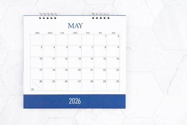 Beyaz mermer döşeme üzerinde Mayıs 2026 masa takviminin tam üstünde.