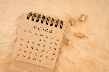 Nisan 2026 Tahta raptiyeli masa takvimi Kahverengi buruşuk kağıt arkaplan.