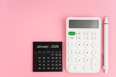 Ocak 2026 takvim ve beyaz hesap makinesi pembe arkaplanlı kalem, kopya alanı olan konum.