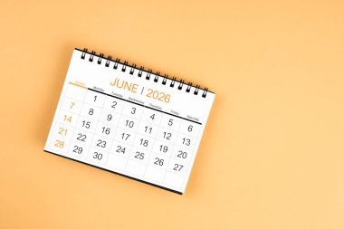 Sarı pastel arka planda Haziran 2026 masa takviminin üst görünümü.