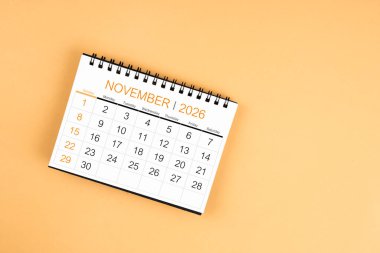 Sarı pastel arka planda Kasım 2026 masa takviminin üst görüntüsü.