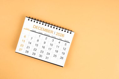 Sarı pastel arka planda Aralık 2026 masa takviminin üst görünümü.