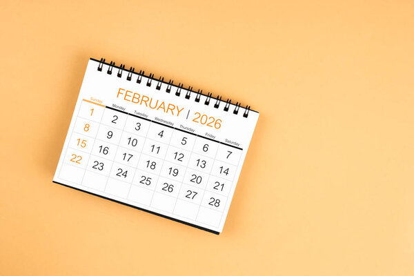 Верхний вид февраля 2026 настольный календарь на желтом пастельном фоне.