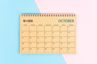 Ekim 2026 Pembe ve mavi arkaplan üzerine kahverengi kağıt takvim.