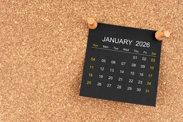 Tahta raptiyeli Ocak 2026 için siyah takvim sayfası, kopya alanı olan konum.