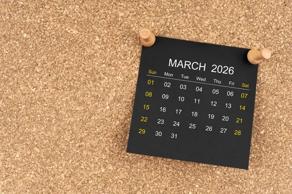 Tahta raptiyeli Mart 2026 için siyah takvim sayfası, kopyalama alanı olan konum.