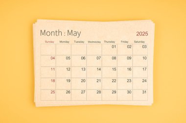Sarı arkaplan üzerine kahverengi geri dönüşüm kağıdından 2025 Mayıs takvimi.