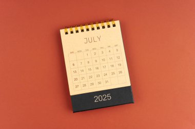 Kırmızı arkaplan üzerine kahverengi el sanatları takviminden Temmuz 2025.