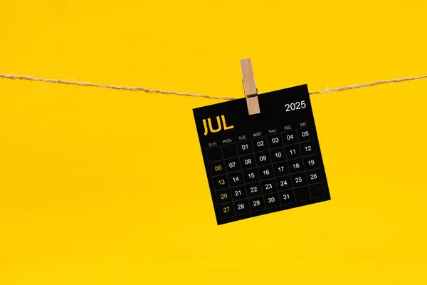July 2025 Black Calendar Hanged Brown Rope Yellow Background — Stock Photo, Image