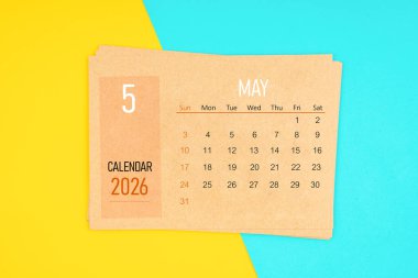 Sarı ve mavi arka planda Mayıs 2026 için kahverengi takvim kartı.