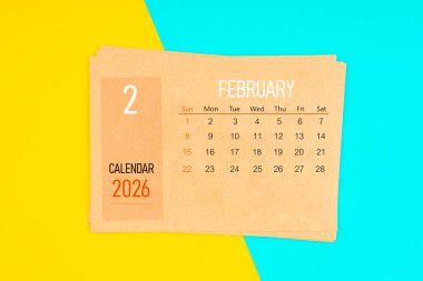 Sarı ve mavi arka planda 2026 Şubat ayı için kahverengi takvim kartı.