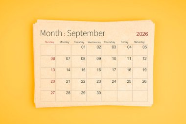 Eylül 2026 takvimi sarı arkaplan üzerine kahverengi geri dönüşüm kağıdından.
