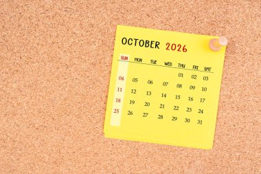 Tahta raptiyeli Ekim 2026 için sarı takvim kağıdı.