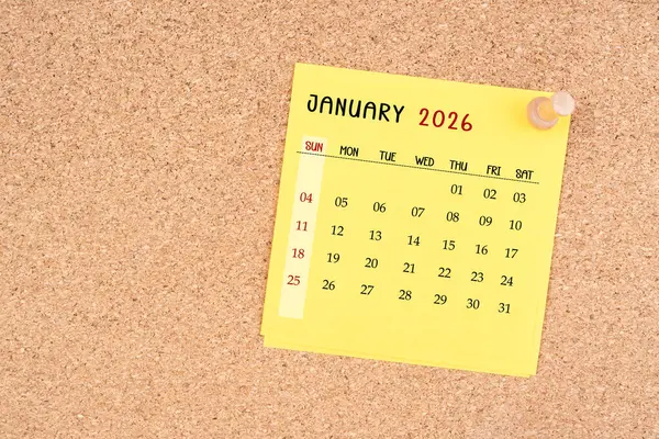 Tahta raptiyeli Ocak 2026 için sarı takvim kağıdı.