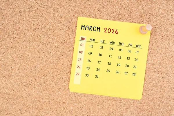 Tahta raptiyeli Mart 2026 için sarı takvim kağıdı.