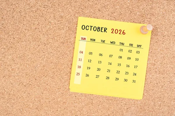Tahta raptiyeli Ekim 2026 için sarı takvim kağıdı.