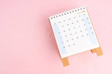 2026 Haziran 'ında, çiçek desenli pembe bir takvim üzerinde düz bir şekilde yatıyordu..