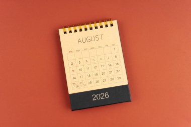 Kırmızı arkaplan üzerine kahverengi el işi kağıdından Ağustos 2026 takvimi.