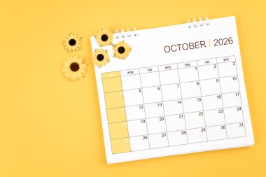 2026 Ekim masa takvimi ve ayçiçekleri sarı arkaplan üzerinde, konum kopya alanı ile.