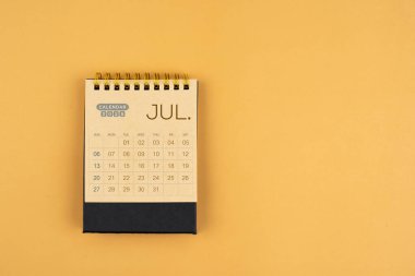 Sarı zemin üzerine kahverengi el işi kağıdından Temmuz 2025 takvimi.