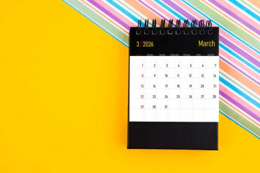 Sarı zemin üzerinde Mart 2026 için masa takvimi, kopyalama alanı olan konum.