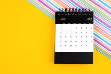 Sarı zemin üzerinde Temmuz 2026 için masa takvimi, kopyalama alanı olan konum.
