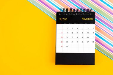 Sarı zemin üzerinde Kasım 2026 için masa takvimi, kopyalama alanı olan konum.