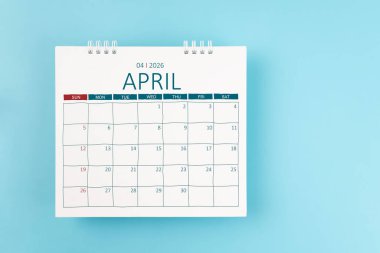 2026 Nisan ayının masa takvimi mavi arka planda 2026 yılı için. Düz yatıyordu.