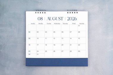 Ağustos 2026 gri çimento duvar arka planında masa takvimi. Yıllık takvim sayfası.