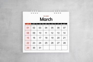 Mart 2026 gri çimento duvar arka planında masa takvimi. Yıllık takvim sayfası.