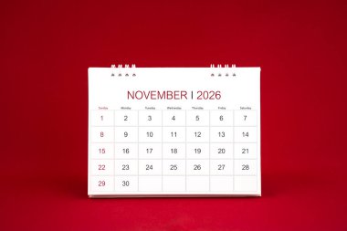 Kasım 2026 beyaz masa takvimi koyu kırmızı zemin üzerinde duruyor.