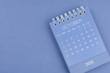 Ekim 2026 takvimi mavi arka planda. Planlama ve düzenleme için masa takvimi.