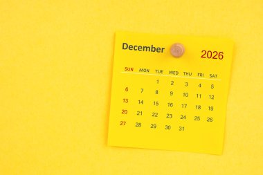 Sarı zemin üzerinde raptiye bulunan Aralık 2026 takvim sayfası.