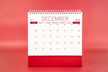 Aralık 2026 Kırmızı arkaplanda boş masa takvimi.