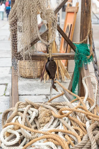 still life in vertical view with different marine tools such as ship ropes, old pulley and fishing nets
