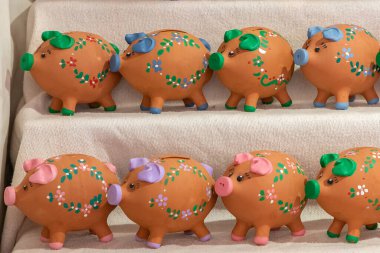 Bir teşhir edicinin yatay görüntüsü ve hatıra olarak satılık bazı dekoratif domuz kumbaraları.