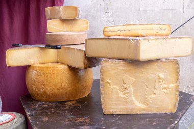 ALCALA DE HENARES, MADRID, SPAIN - 9 Ekim 2022: Alcala de henares şehrindeki bir ortaçağ festivalinin kutlaması sırasında ahşap bir tezgahın üzerinde farklı peynir türlerinin geniş porsiyonları