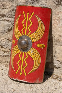 Antik Roma İmparatorluğu 'ndan gelen lejyoner bir askerin kalkanı olan canlı kırmızı Scutum Augusta' nın dikey görüntüsü güç ve otorite uyandırıyor.