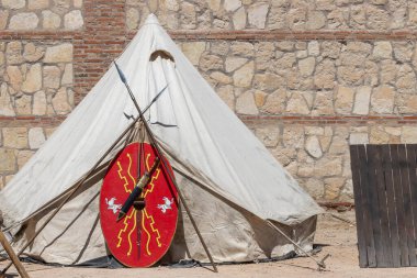 Antik Roma İmparatorluğu 'nun yedek birliklerinden bir askerin çadır, mızrak, kalkan ve kılıcının yatay manzarası.