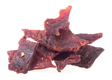 Beyaz arka planda izole edilmiş baharatlı kurutulmuş et yığını.