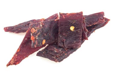 Kurutulmuş sığır eti parçaları beyaz arka planda izole edilmiş. Baharatlı ve kurutulmuş et..