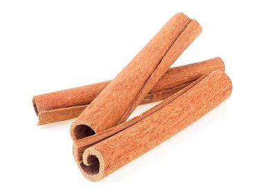 Beyaz arka planda üç tane tarçın çubuğu var. Tarçın çubuğu baharatı.