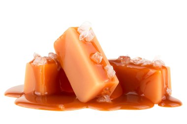 Karamel soslu lezzetli şekerler ve beyaz arka planda izole edilmiş deniz tuzu.