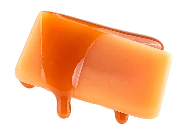 stock image Caramel sauce flowing on caramel candy, isolated on a white background. Levitating caramel candy.