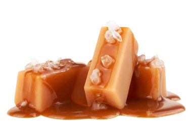 Karamel soslu lezzetli şekerler ve beyaz arka planda izole edilmiş deniz tuzu.