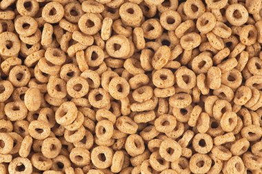 Arkaplanı bal olan lezzetli mısır gevreği halkaları, üst manzara. Sağlıklı kahvaltı..